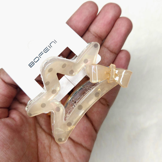Clear hair clip with bow held in a hand, brand 'BOFEINI' visible