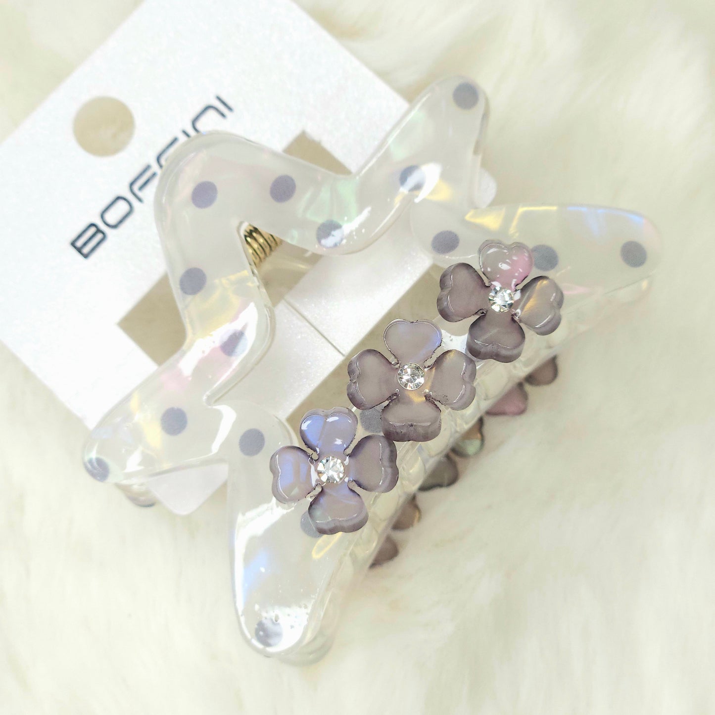 Clear hair clip with purple heart-shaped stones on a white background