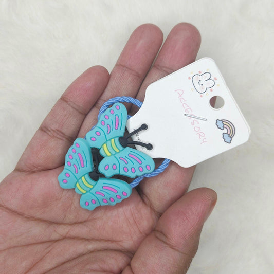 Butterfly-shaped hair tie held in a hand with a white background