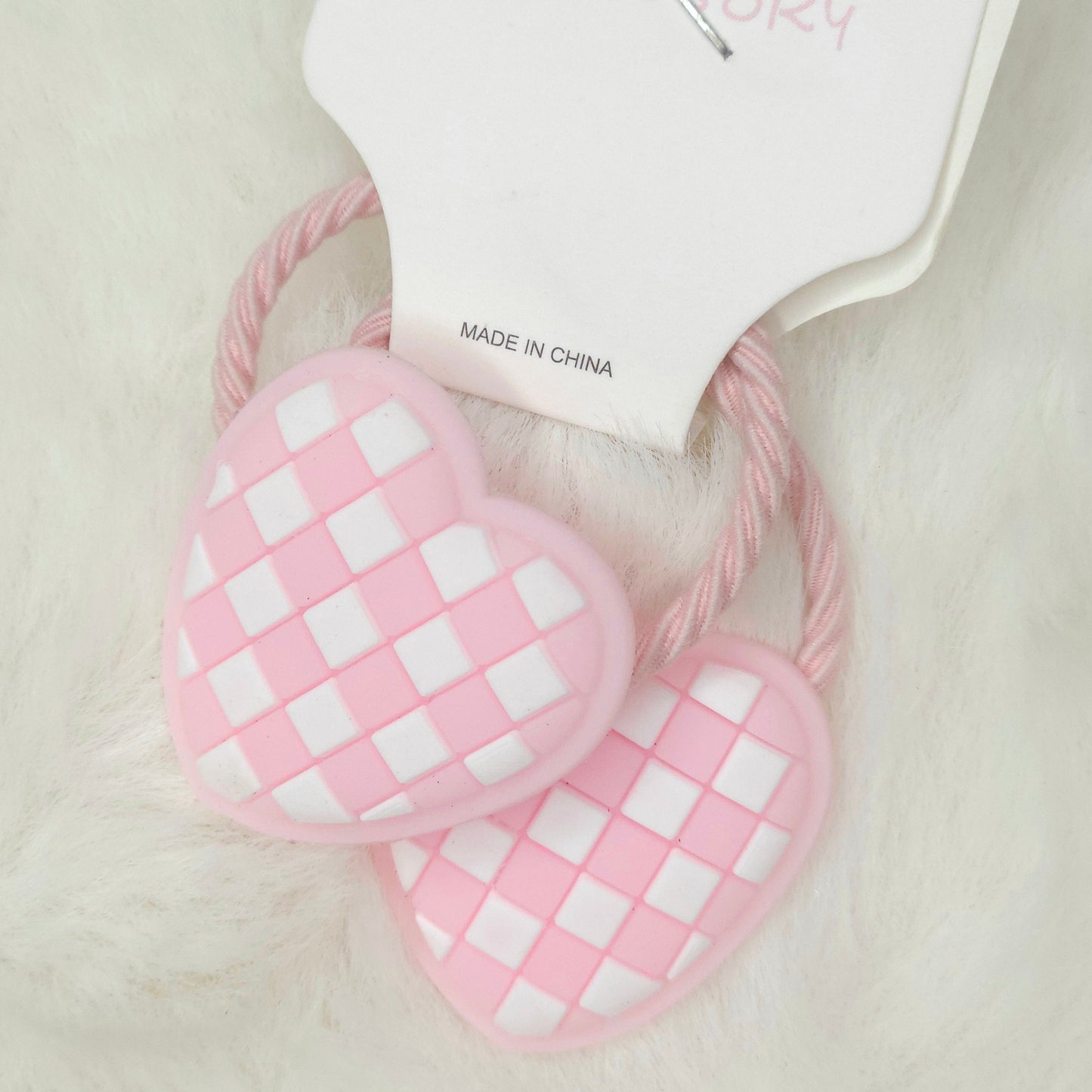 Pink checkered hair ties on a light background