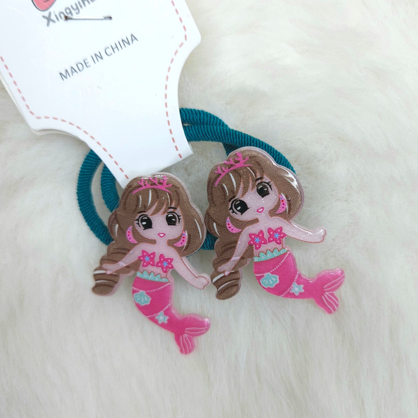 Mermaid-themed hair ties with cartoon mermaids on a white background