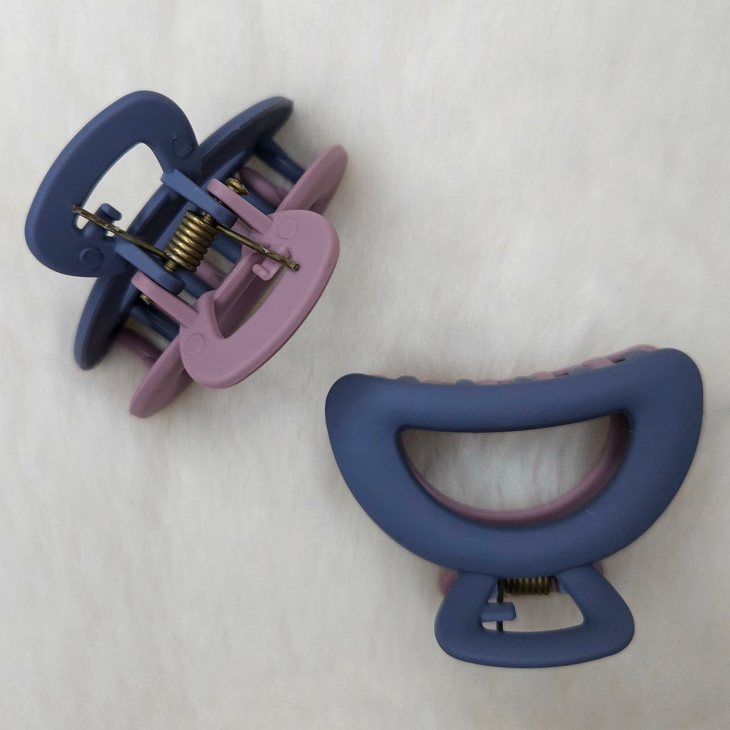 Two purple and blue shared hair clips on a white background