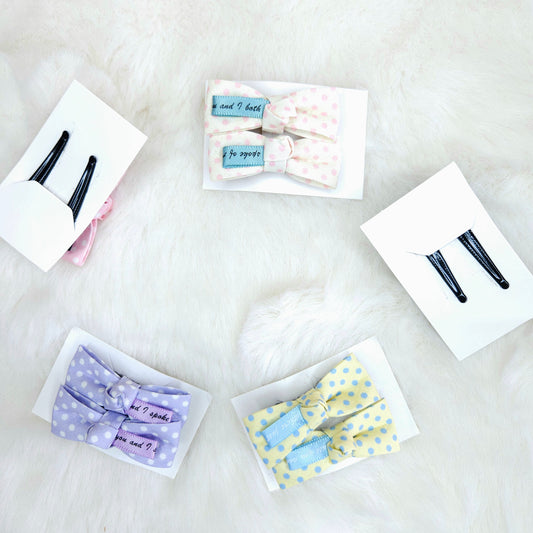 Collection of hair accessories including bows and clips on a white surface