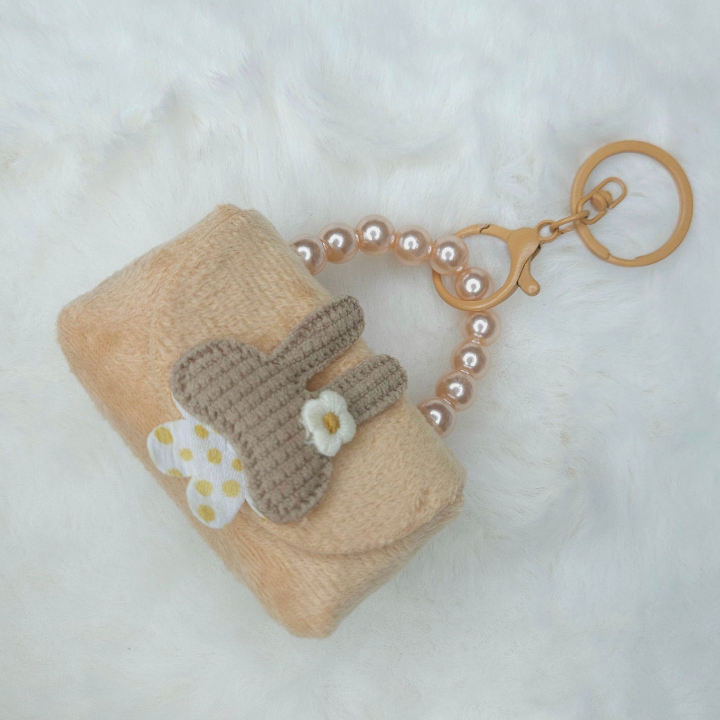 Keychain with a small pouch and butterfly design on a white background