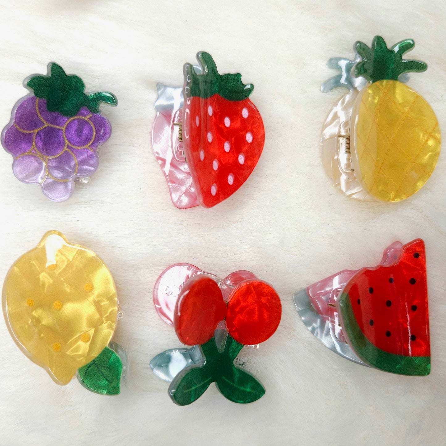 Colorful fruit-shaped acrylic hair claw clips on a white background