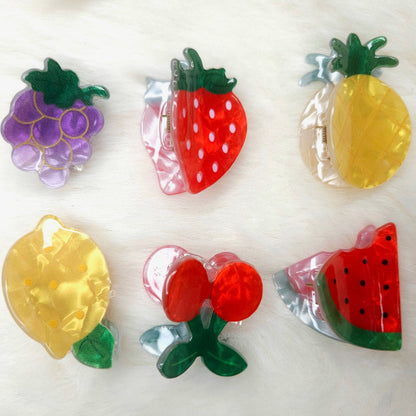 Colorful fruit-shaped acrylic hair claw clips on a white background