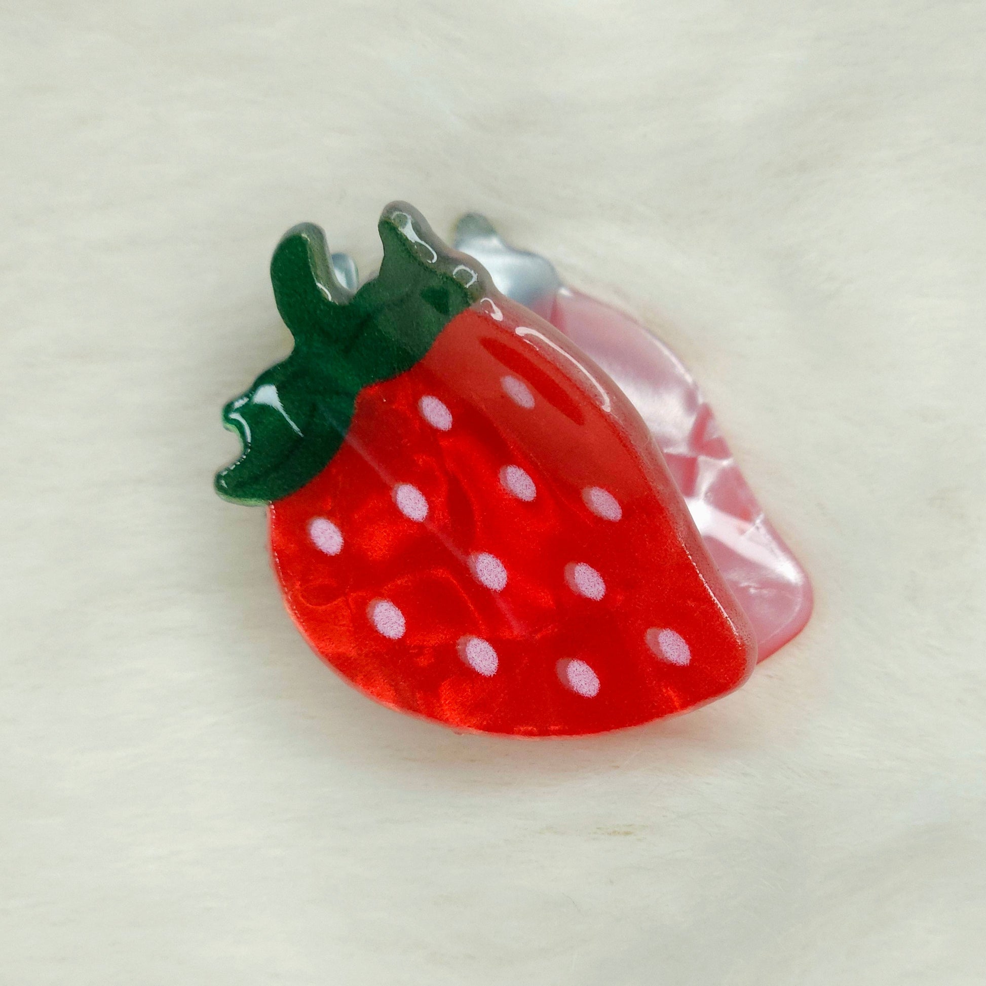 Strawberry-shaped hair clip on a white background
