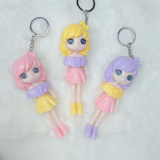 Three colorful keychains shaped like small dolls on a white background