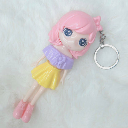 Keychain with a cartoon character featuring pink hair and a yellow skirt on a white background