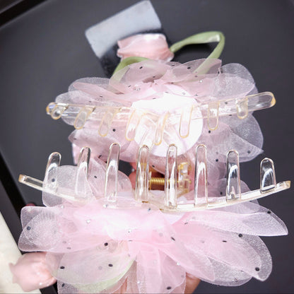 Pink floral hair clip on a black tray