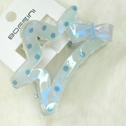 Translucent blue hair clips with polka dots on a white background
