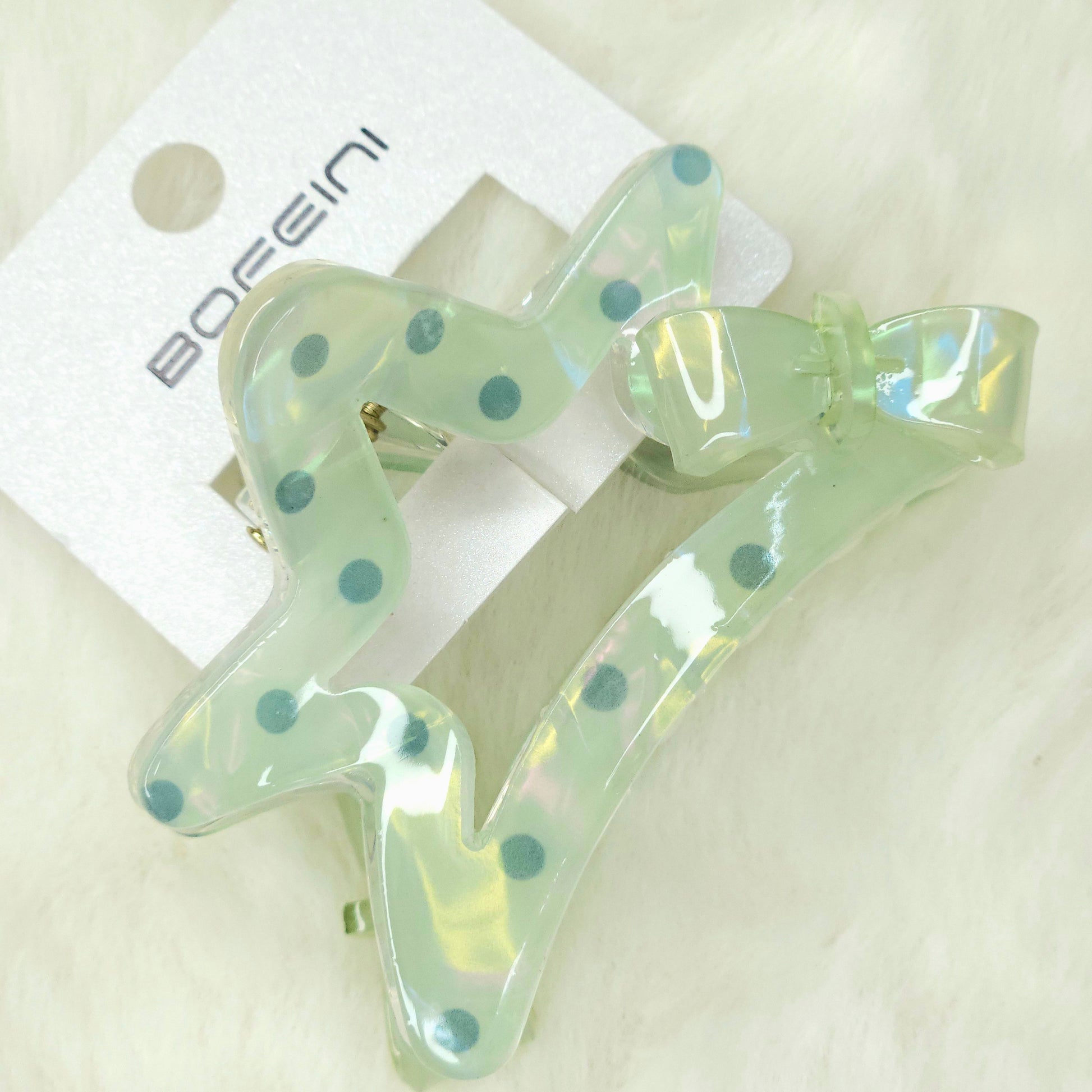 Clear hair clip with blue dots on a white background