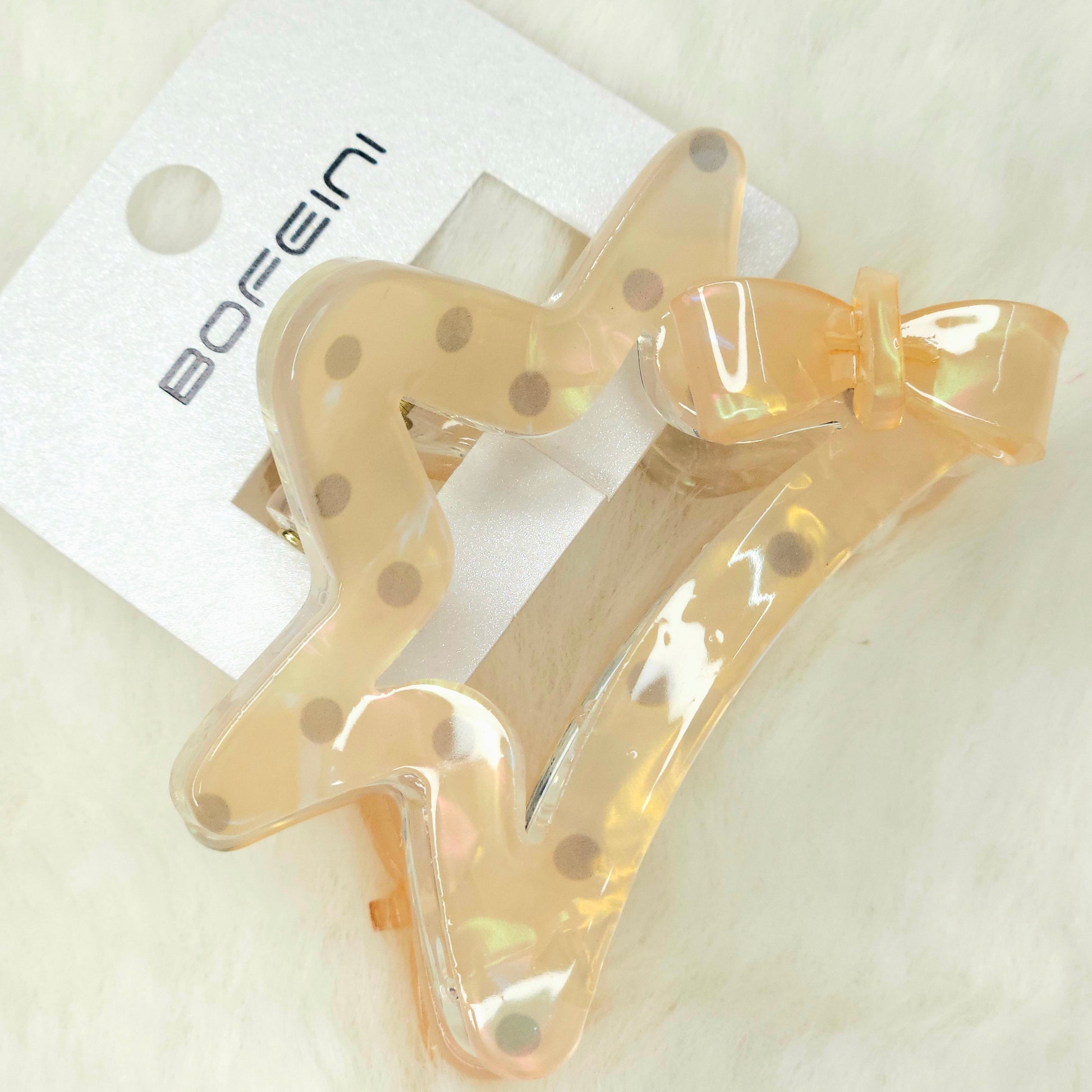 Beige hair clips with polka dot design on a white background