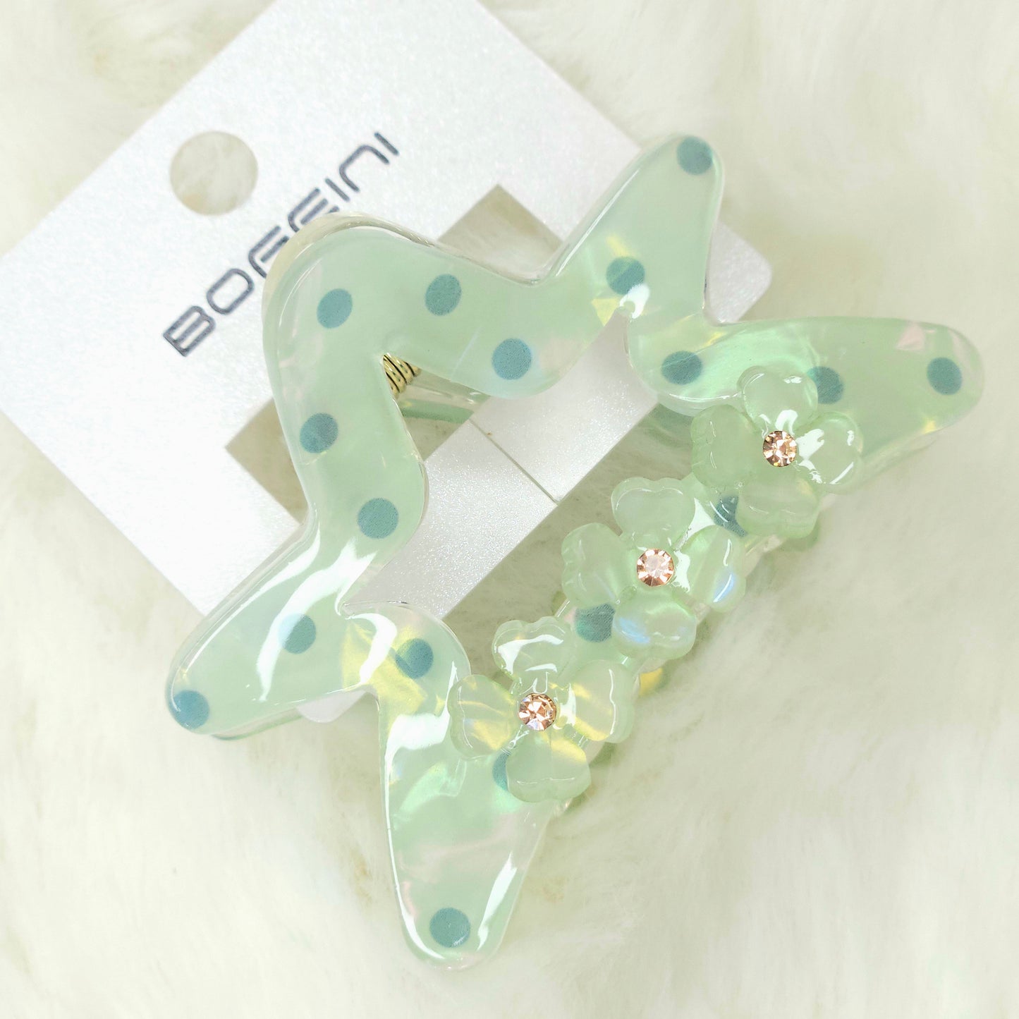 Decorative hair clips with floral details on a white background