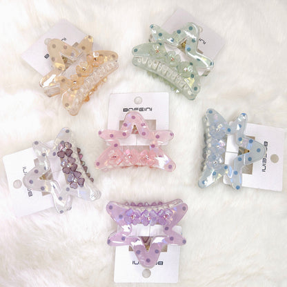 Set of colorful butterfly-shaped hair clips on white cards with visible branding.