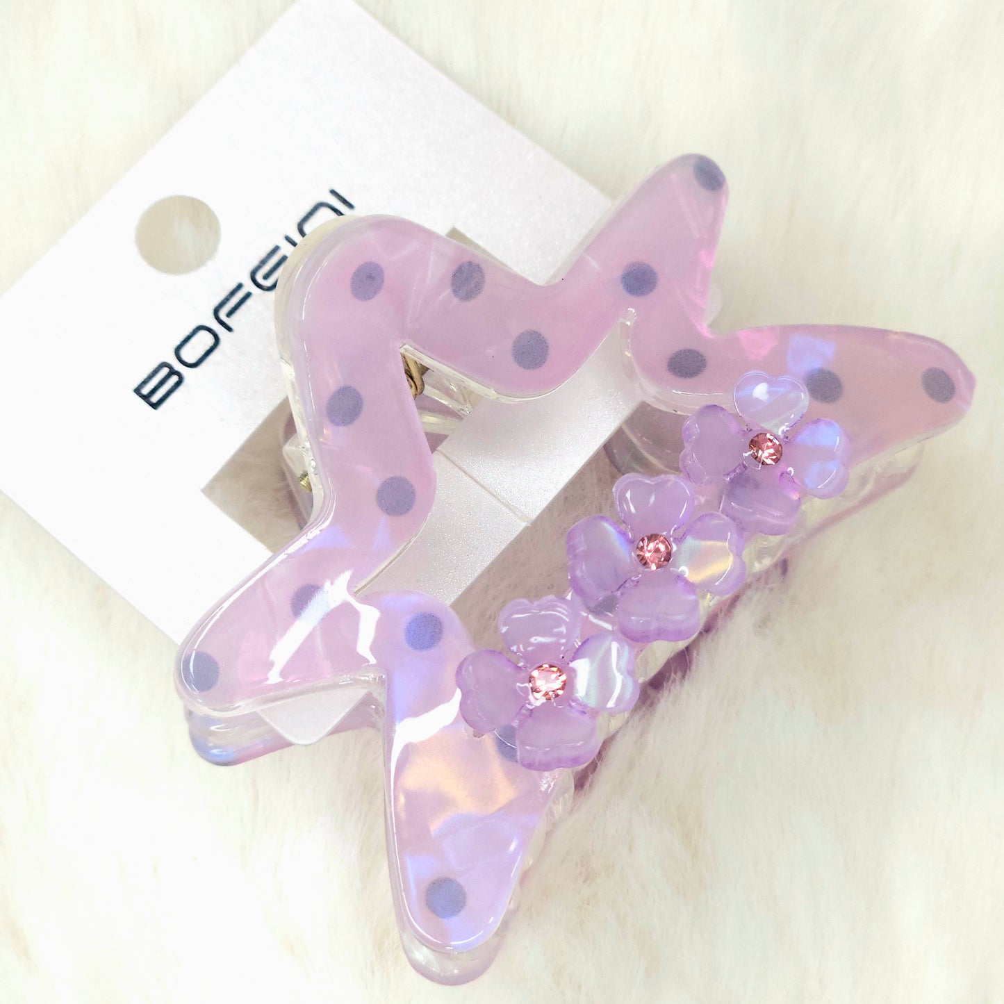 Star-shaped hair clip with floral details on a white background