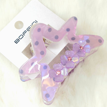 Star-shaped hair clip with floral details on a white background