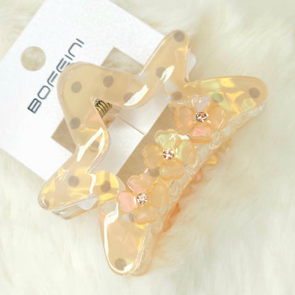 Decorative hair clip with floral details on a white background