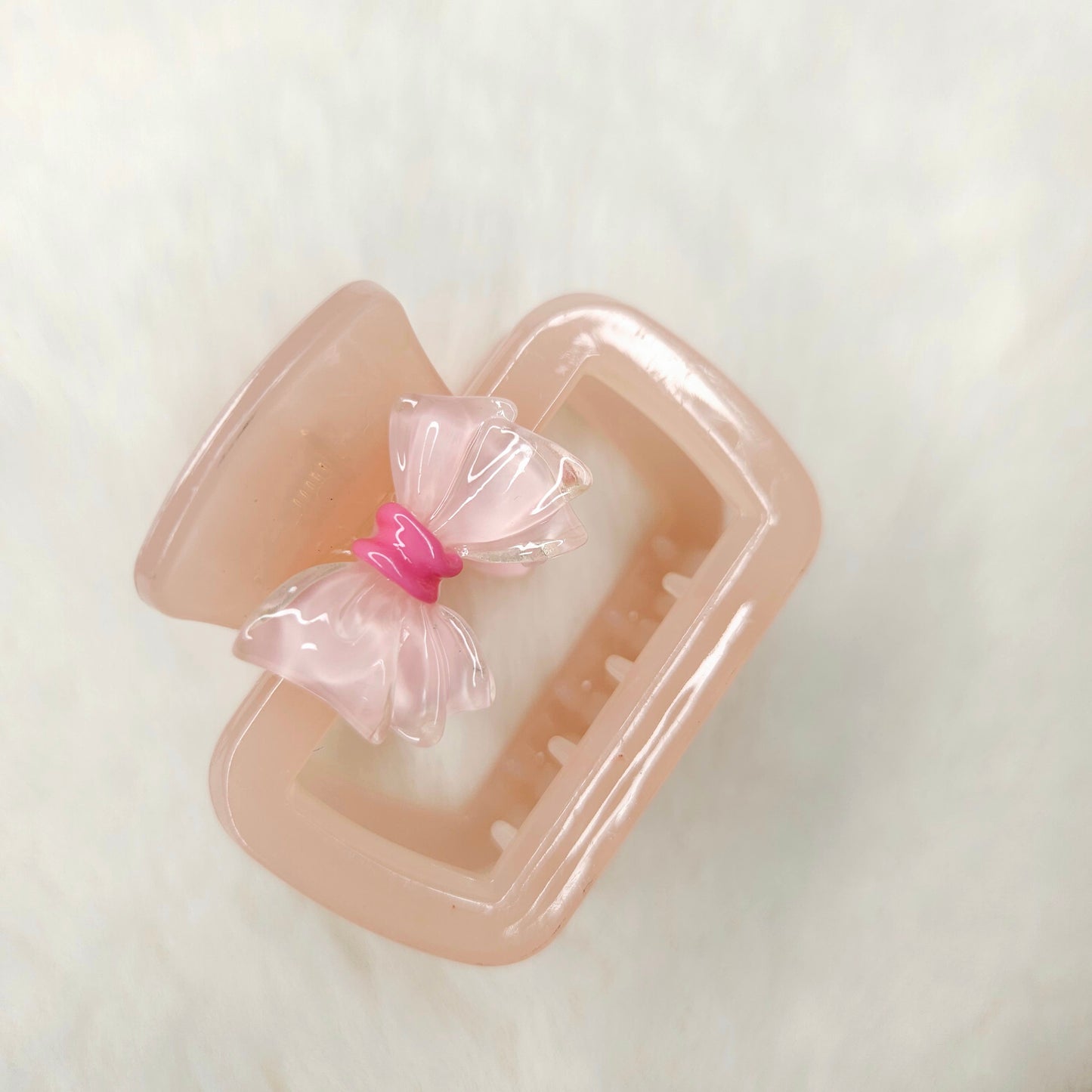 Pink hair claw with a pink bow on a white background