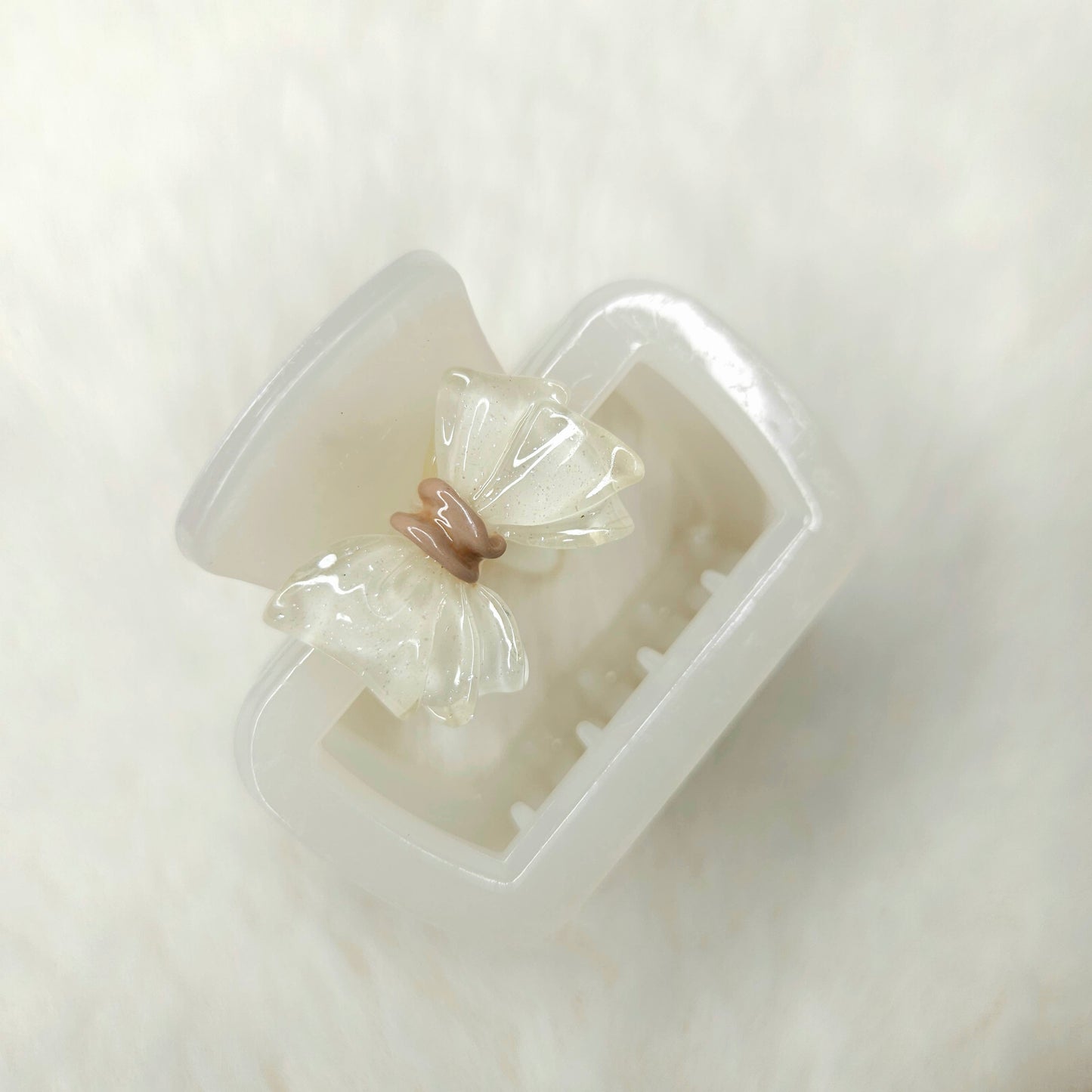 Clear white hair clip with a bow-shaped cavity on a white background