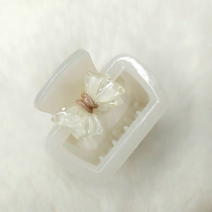 Clear white hair clip with a bow-shaped cavity on a white background