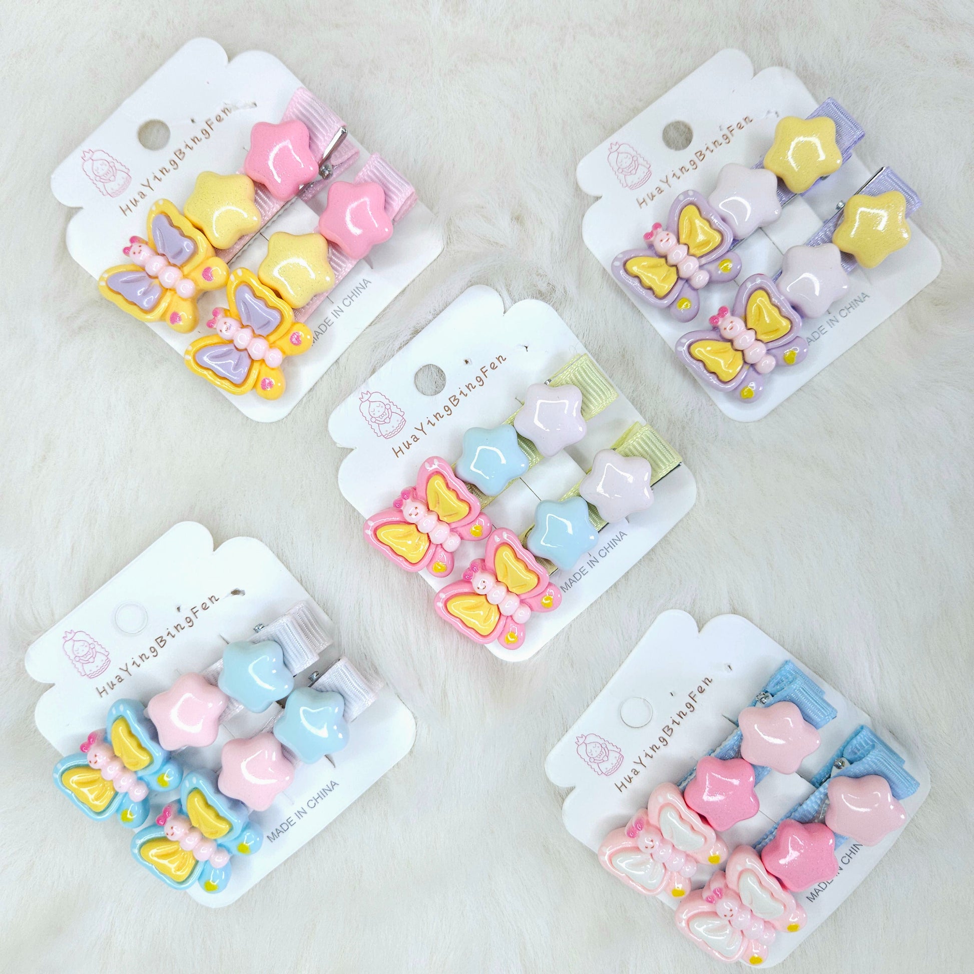 Set of five packages containing colorful butterfly and heart-shaped hair clips on a light gray background.