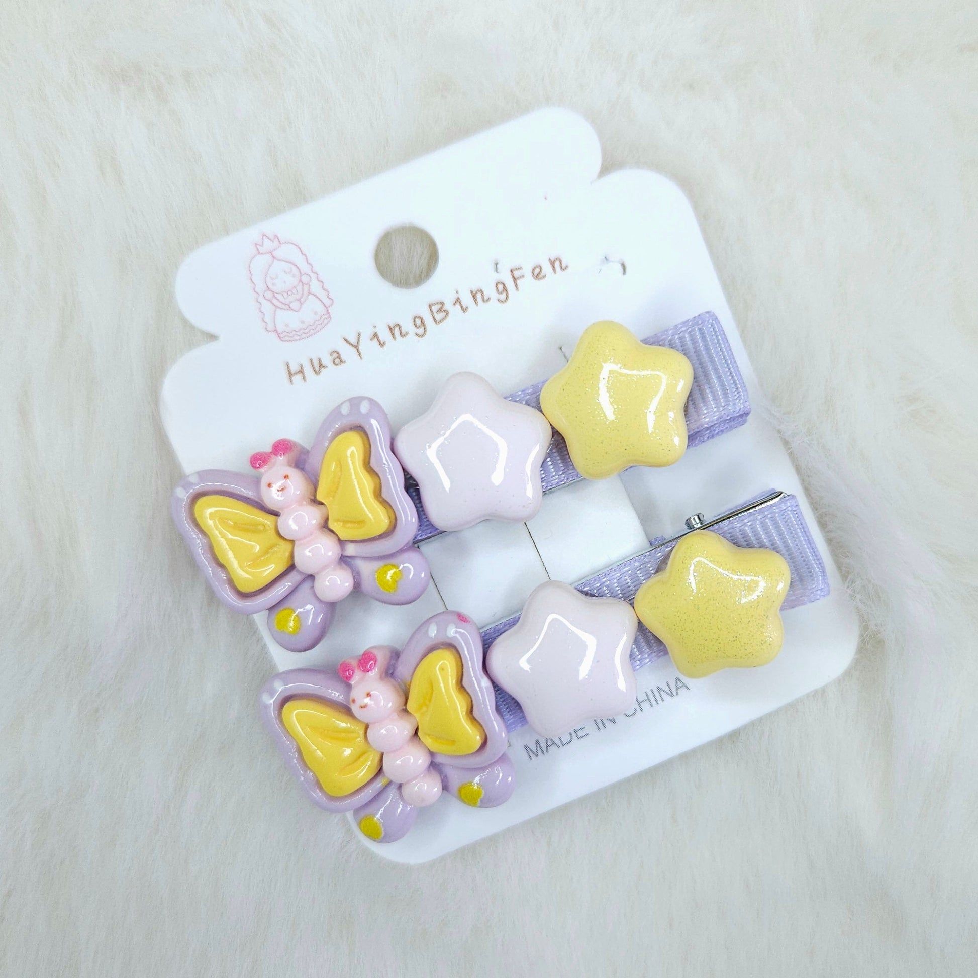 Set of butterfly and star-shaped hair clips on a branded card against a light background