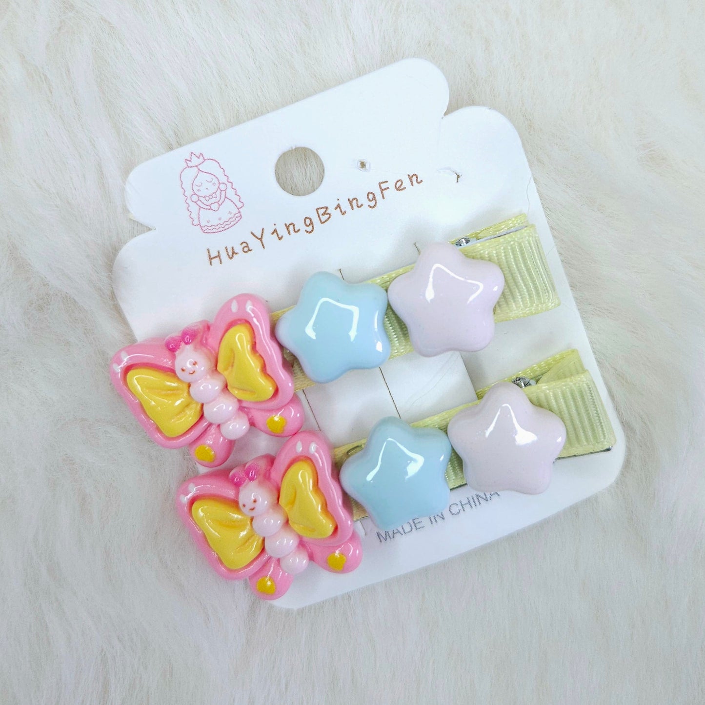 Set of colorful hair clips on a branded card against a light background