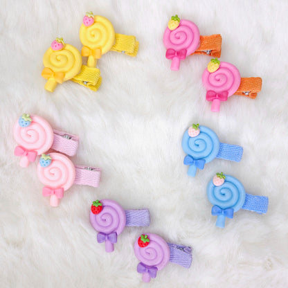 Set of colorful candy-themed hair clips on a white background