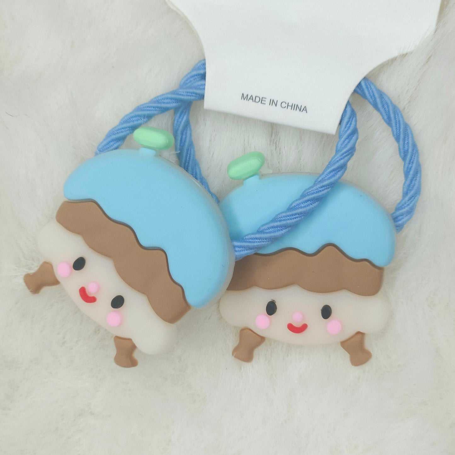 Two cute character-themed hair ties with a 'Made in China' tag on a light background