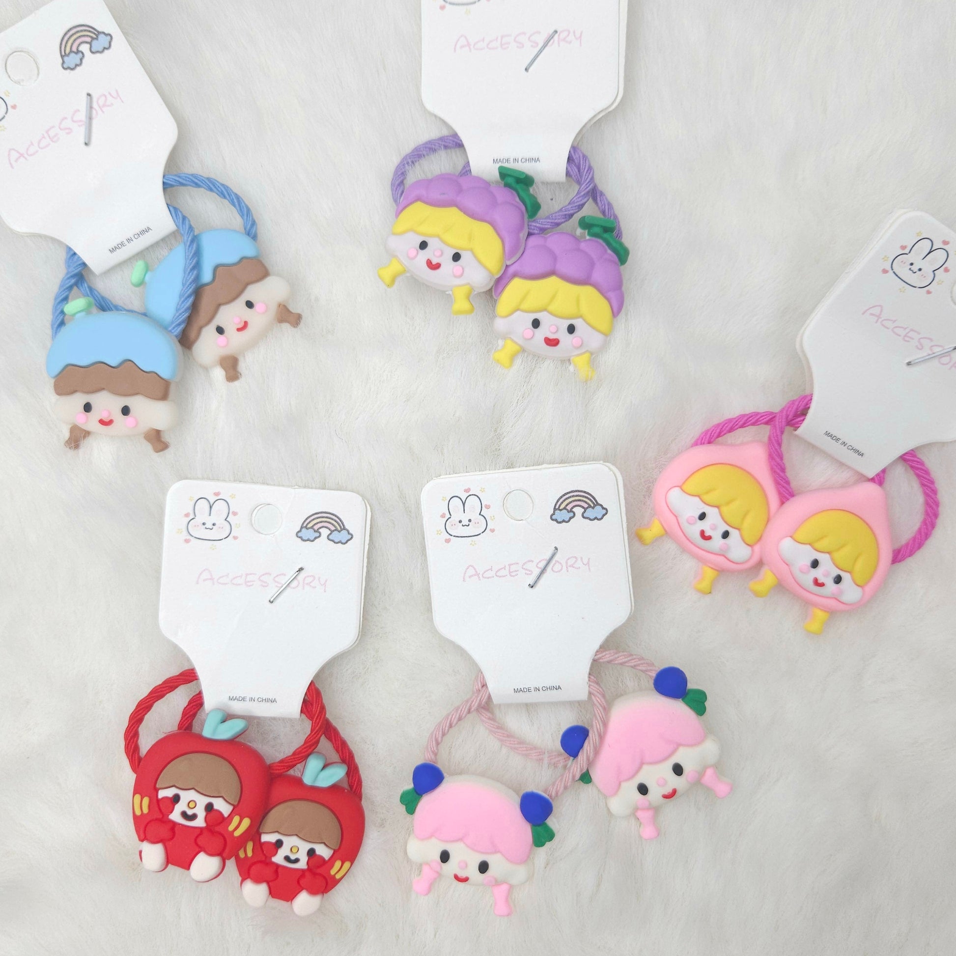 Set of colorful hair ties with cartoon characters on a light gray background