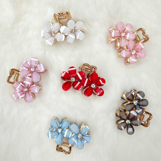 Set of colorful flower-shaped hair clips on a light background