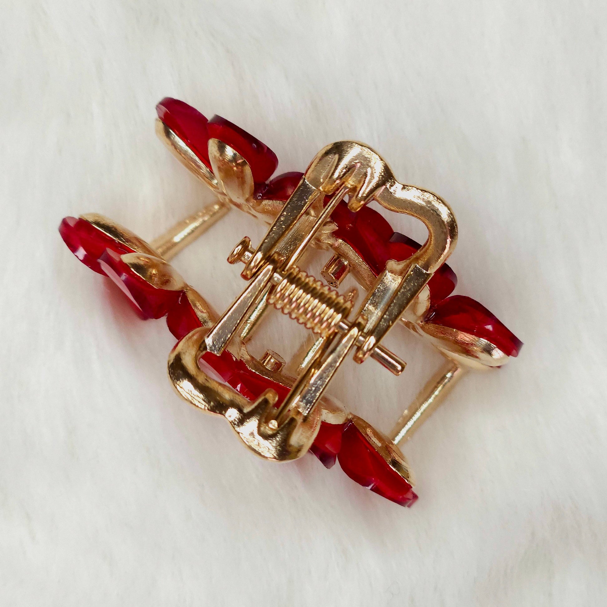 Red-Gold hair claw with red stones on a white background