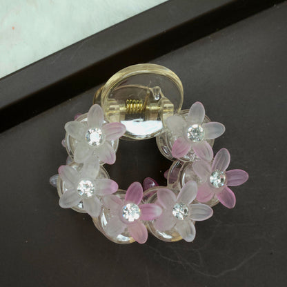 Small, light pink floral hair claw with shimmering translucent resin beads shaped like flowers and subtle sparkle from embedded rhinestones.