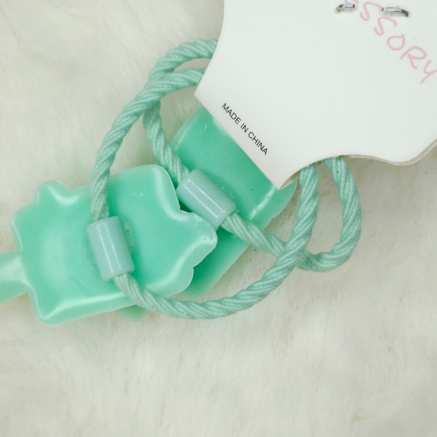 Light blue hair tie with a bow on a white background