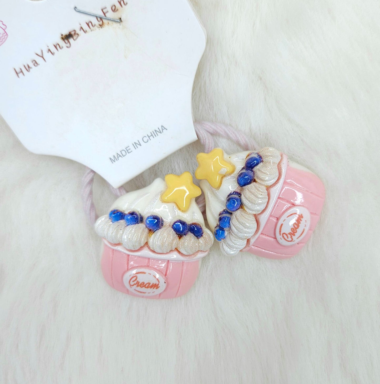 Pink sandal with star and blue bead hair ties on a white background