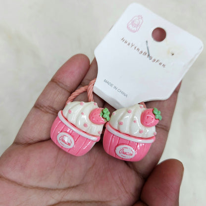 Pink and white hair ties with a 'Made in China' label on a beige background