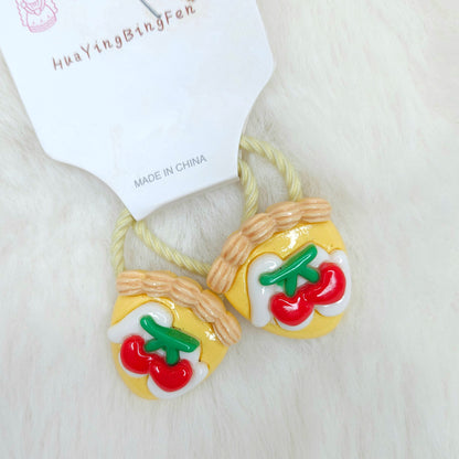 Hair ties with tomato design on a white background, branded 'HuaYingBingFen'.