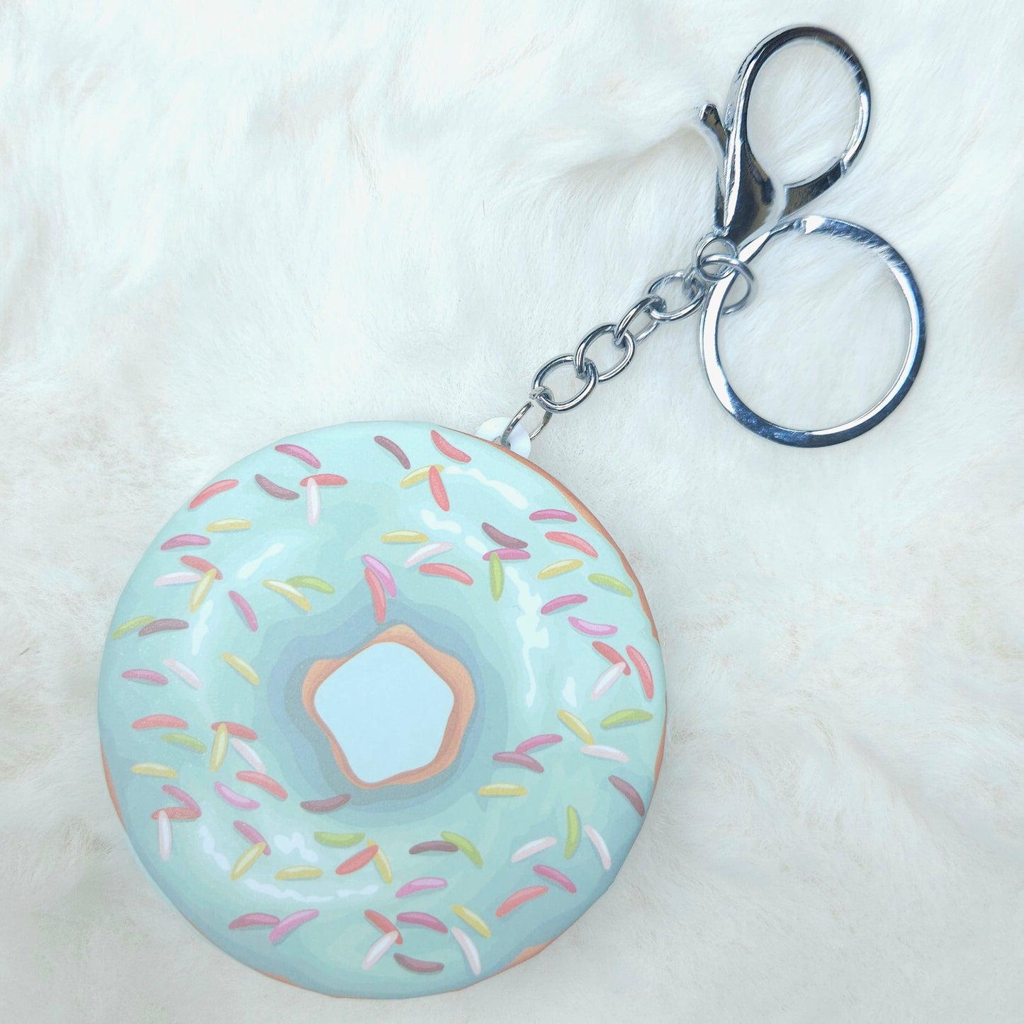 Donut-shaped keychain with sprinkles on a white background