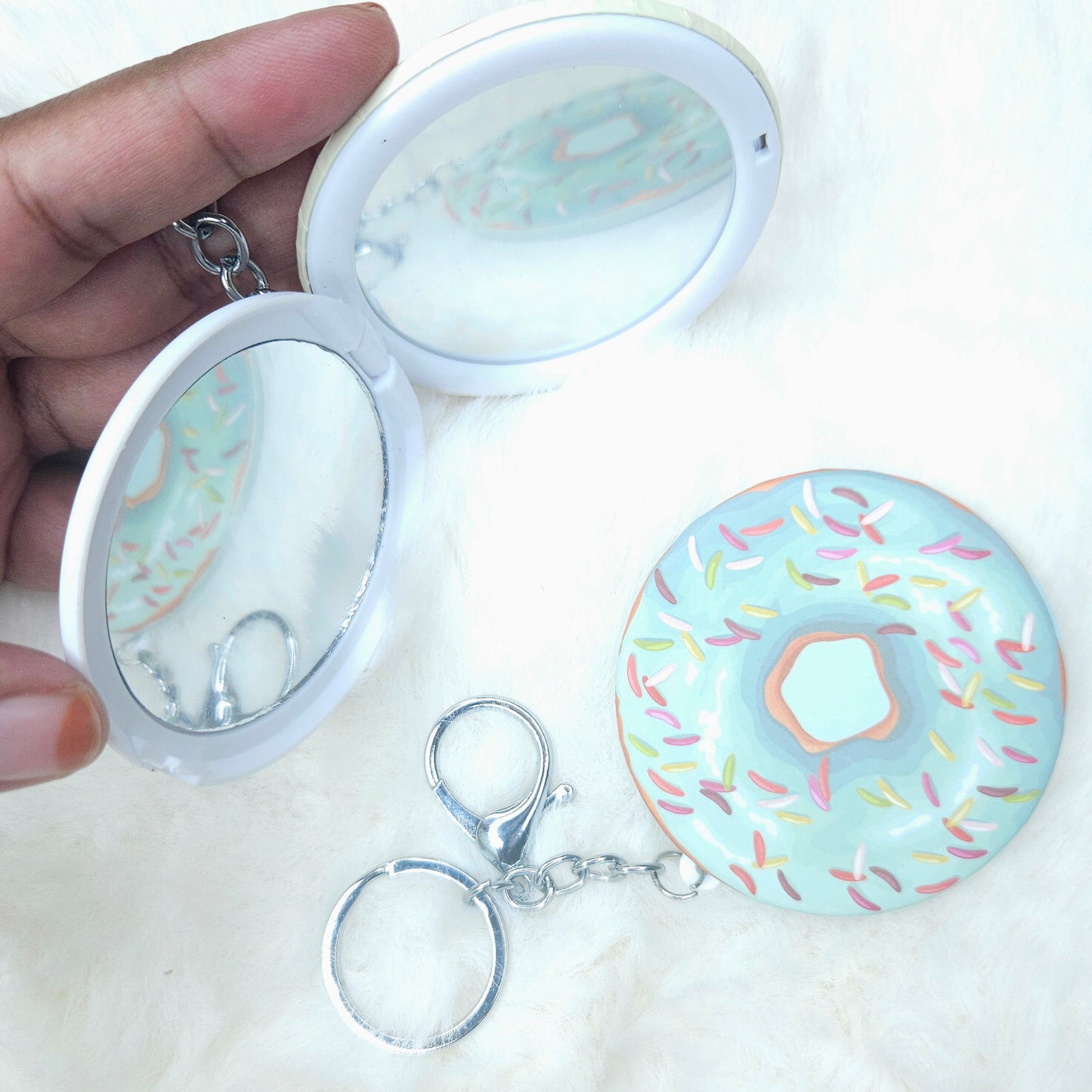 Compact mirror with a donut design on a white background