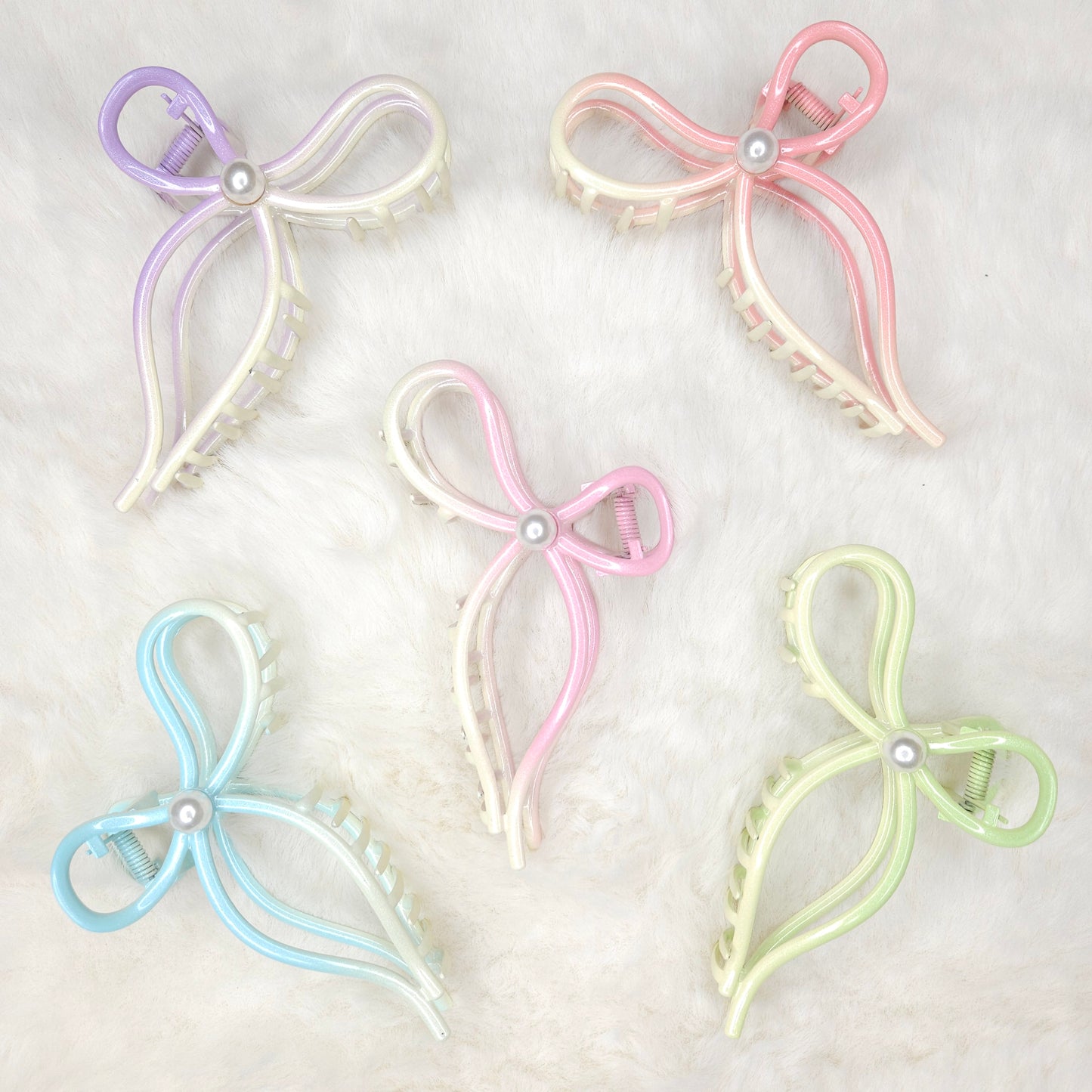 Set of five pastel-colored butterfly-shaped hair clips on a light background