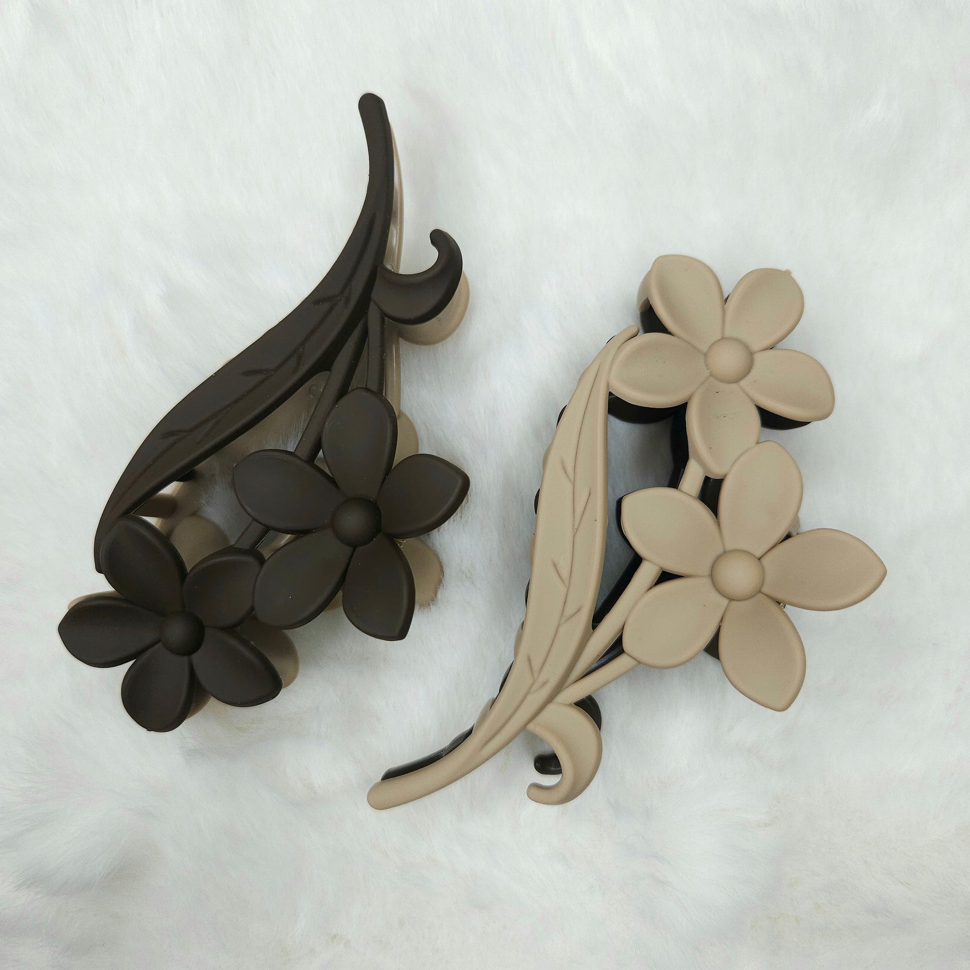 floral and leaf design hair claw clips in black and beige on a white background