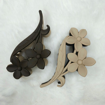 floral and leaf design hair claw clips in black and beige on a white background