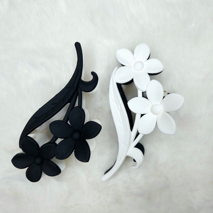 Black and white floral hair clips on a light gray background