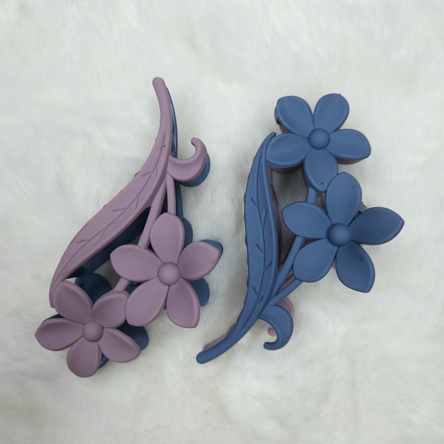 Dual colored blue and purple hair claw clips placed on a white background