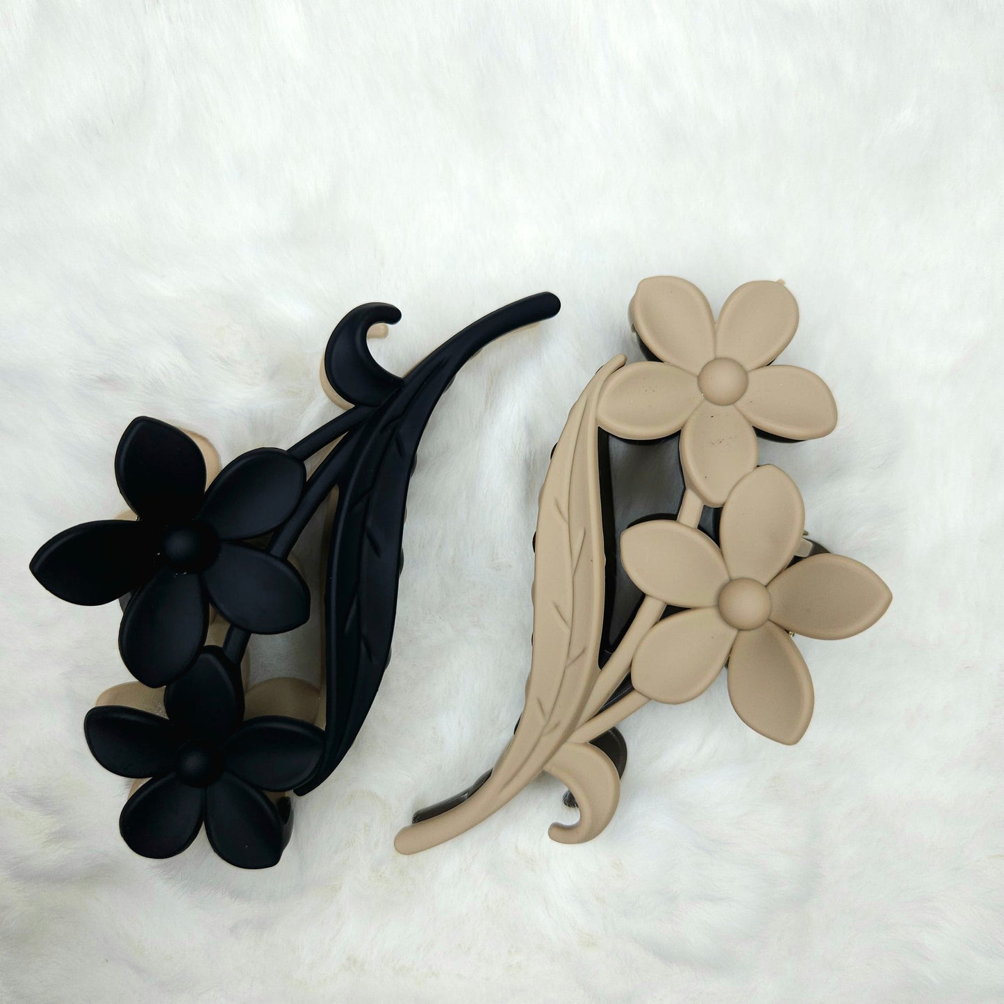 Black and beige floral hair clips on a white background