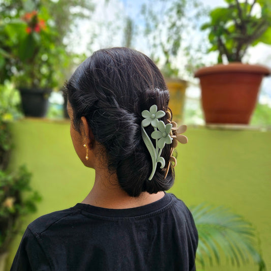 Person with a floral hair accessory in a garden setting