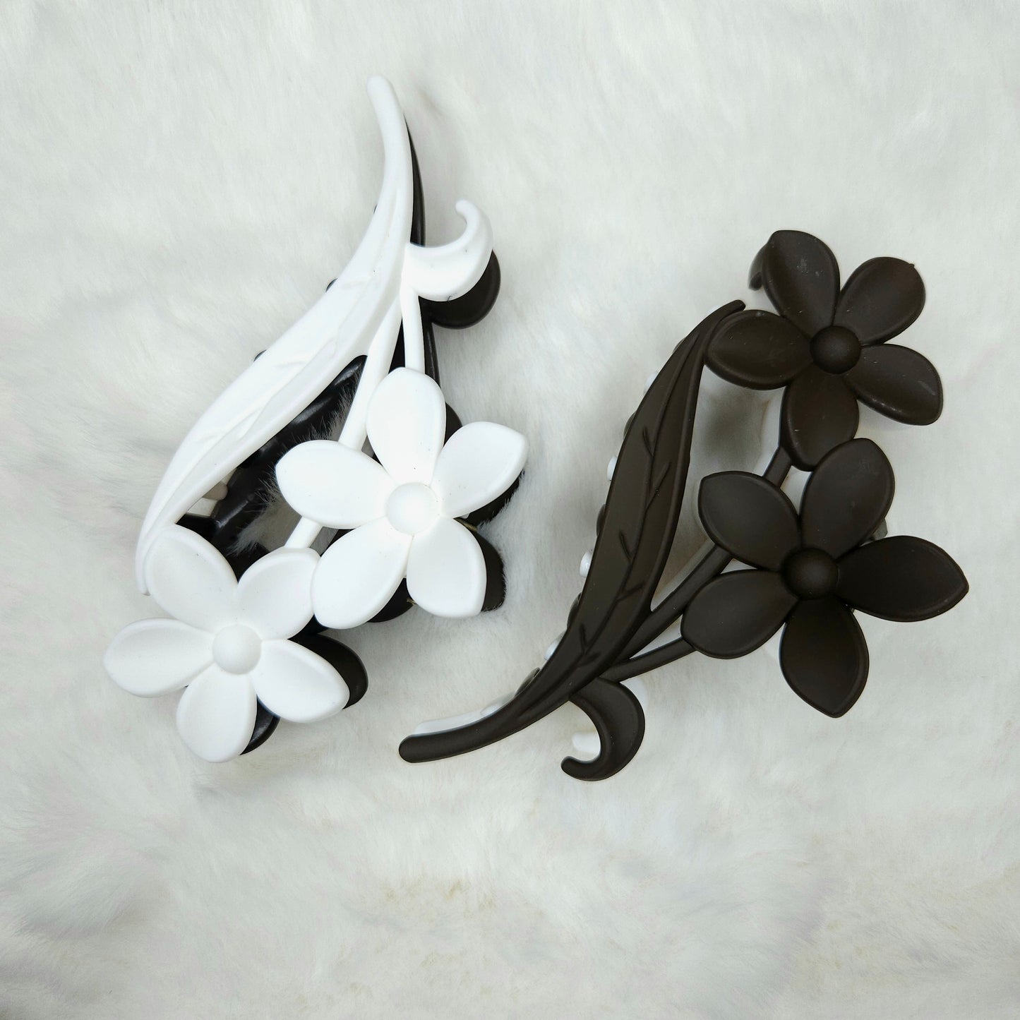 Black and white floral hair claw clips on a light gray background