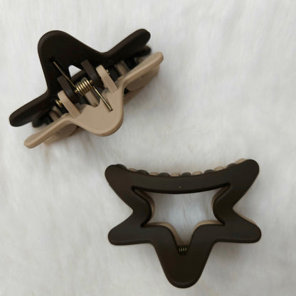 Two hair clips, one black and one beige, on a white background