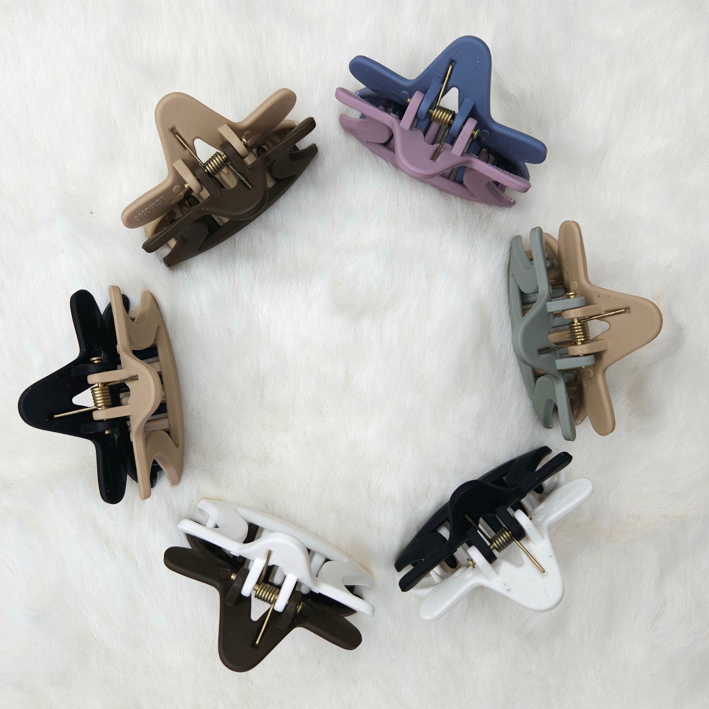 Set of eight hair clips in various colors on a white background shown from top angle